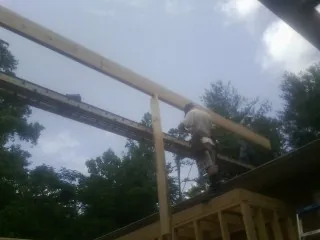 Carpenter setting a ridge beam over a new addition frame — Ice Dam Removal by Roofing Brothers in West Friendship