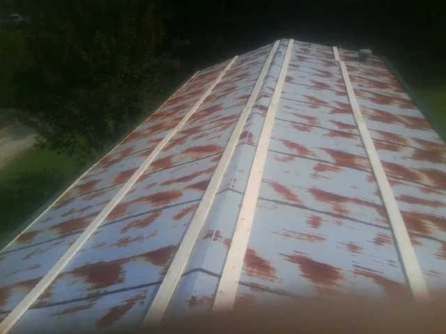 Rusted metal roof panels with new wood purlins before replacement — Storm Damage Roof Repair in West Friendship by Roofing Brothers
