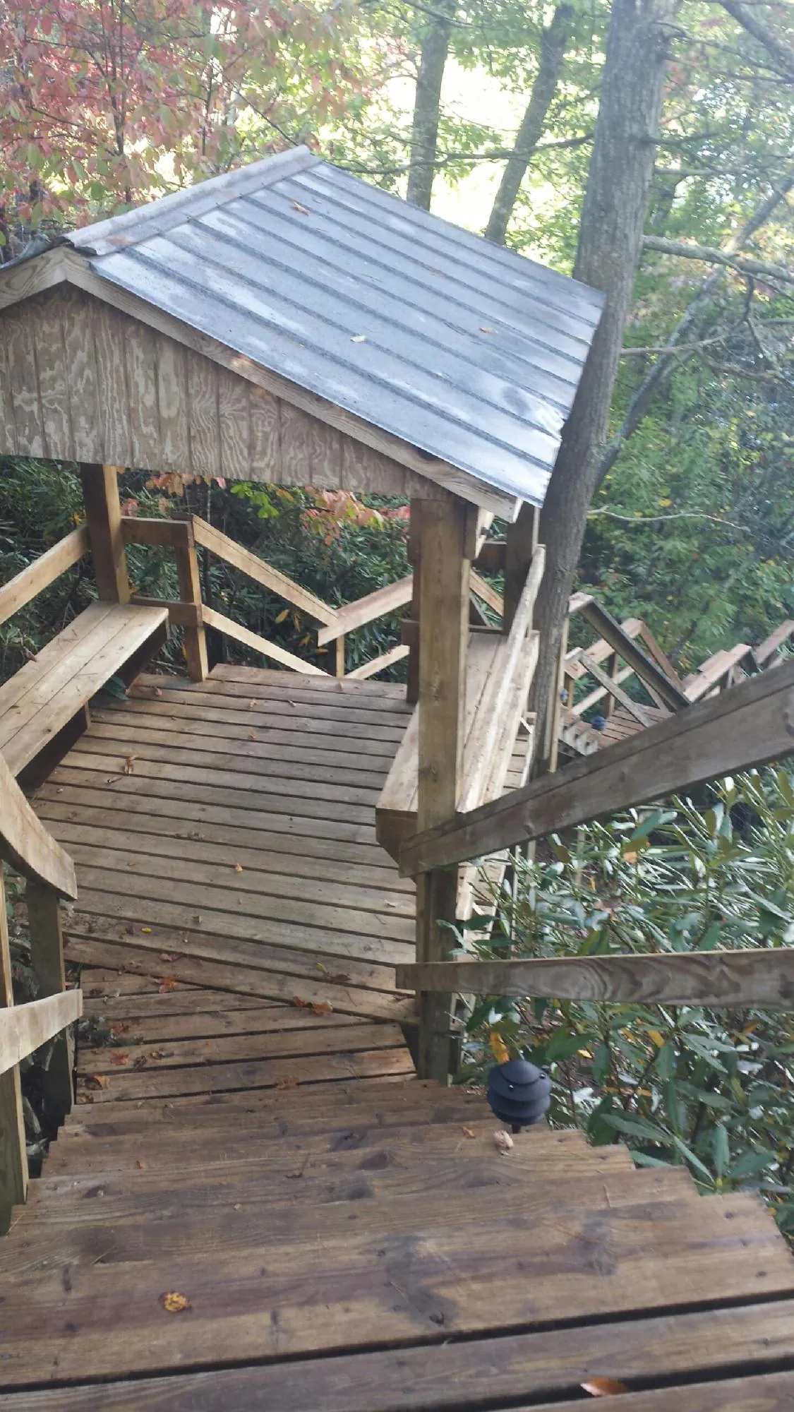 Metal roofed shelter over wooden steps on a wooded walkway — Skylight Repair & Installation work by our crew in West Friendship